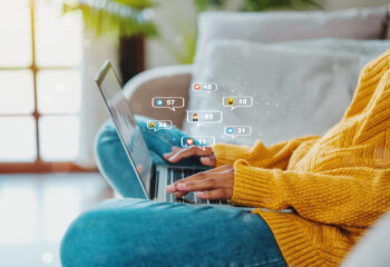 African American teenage woman using a smartphone ,Laptop with Icon communication network social media network pop notification concept.