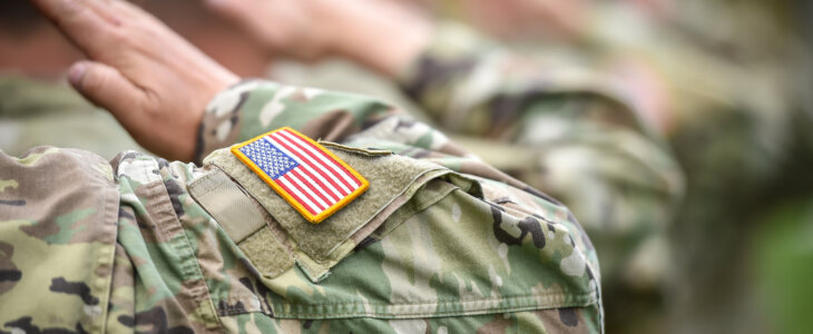 Detail shot with american flag on soldier uniform, giving the honor salute during military ceremony